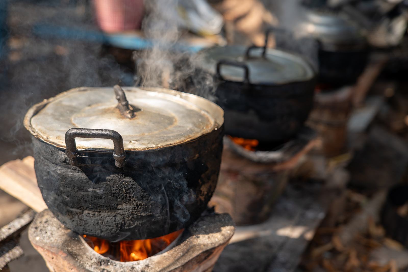 Cooking pots on an open wood fire in a rural outdoor kitchen